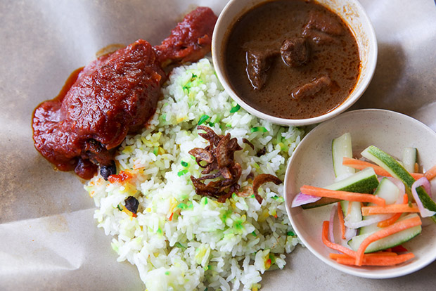 Nasi hujan panas with its colourful grains is accompanied with acar and a choice of ayam masak merah or daging kuzi.