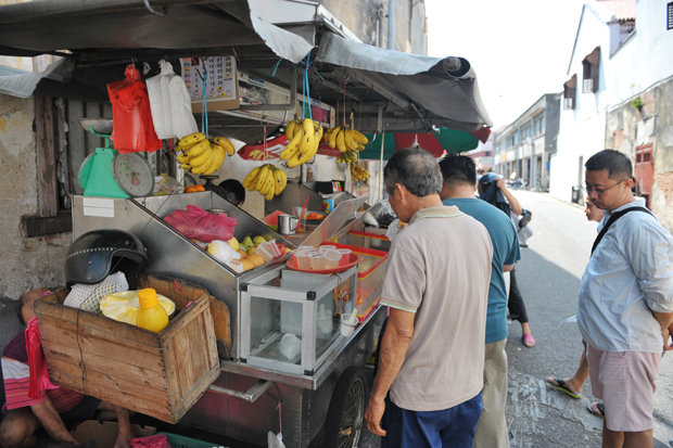 This roadside stall is often crowded as customers stop by for a drink of orange juice or some fresh cut fruits.