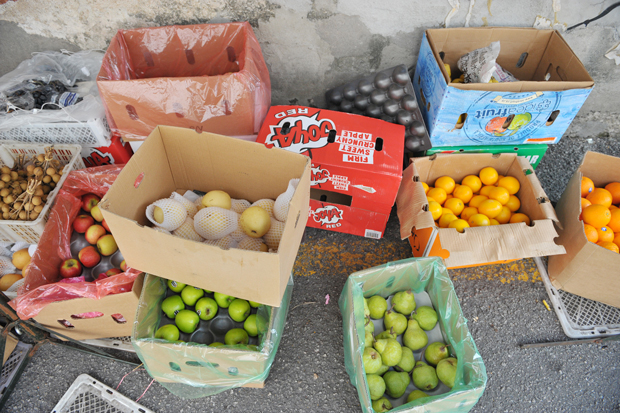 The stall sells imported and local fruits, placed in boxes right next to the stall.