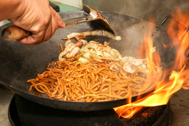 Frying the noodles require skills to handle the heavy wok and strong fire.