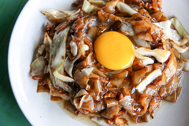 The kuey teow bulan has a raw egg cracked over the fried noodles.