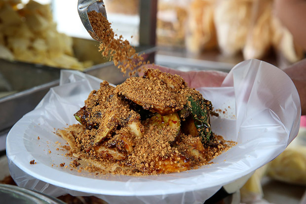Lim adds toasted ground peanuts on top of the rojak.