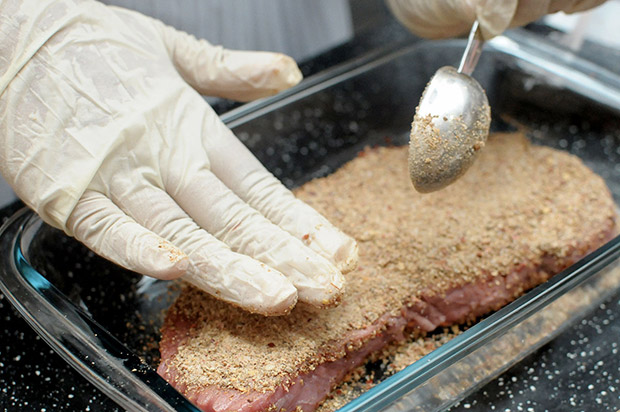 The spice mixture is rubbed onto the pieces of meat.