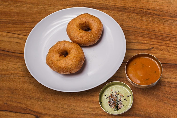 Snack on these fluffy uddin vada or fried lentil doughnuts with chutney and sambar.