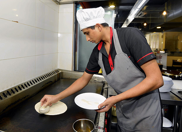 The fermented batter made from multi grains and pulses is swirled into a circle on a hot griddle.