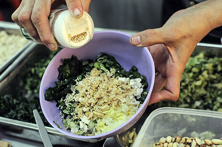 Sprinkling toasted sesame seeds over the Hakka lui cha