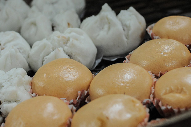 Each bamboo tray is filled with orange coloured lau sar pau and char siew pau.