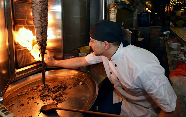 Lighting the fire for the vertical rotisserie to cook the shawarma.