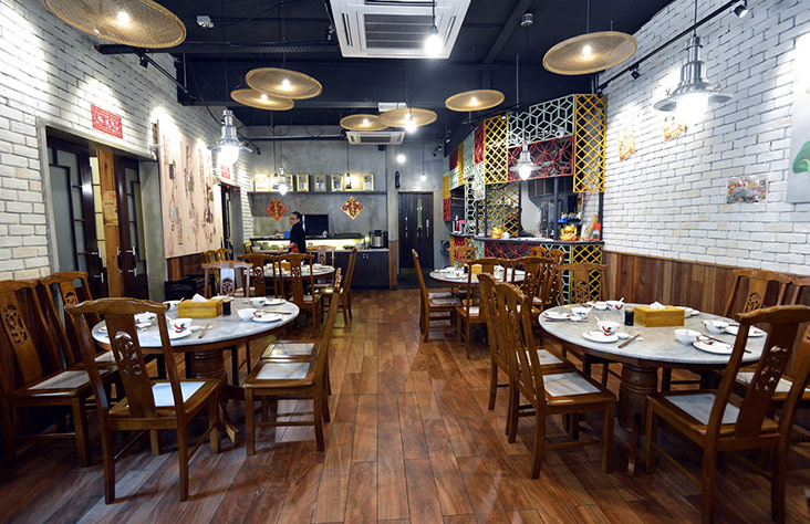 As most of their dishes are eaten family style, the decor at their first shop features round tables.