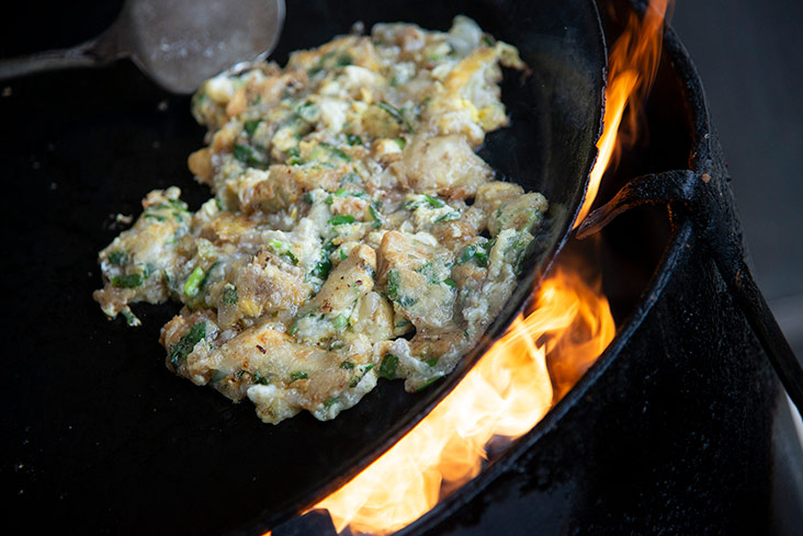 He flips the omelette when it turns golden brown.