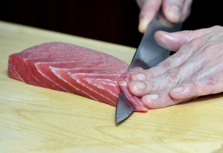 Cutting and prepping the fish before it’s paired with rice.