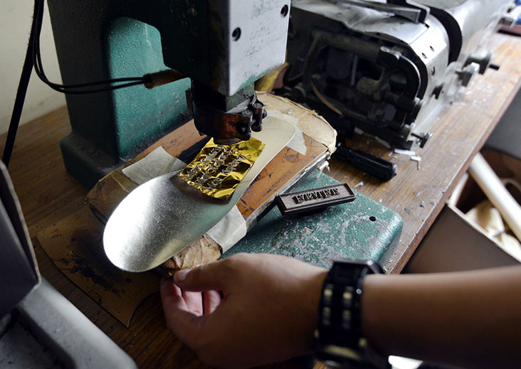 The shoe’s logo is stamped on the inner sole with a machine.