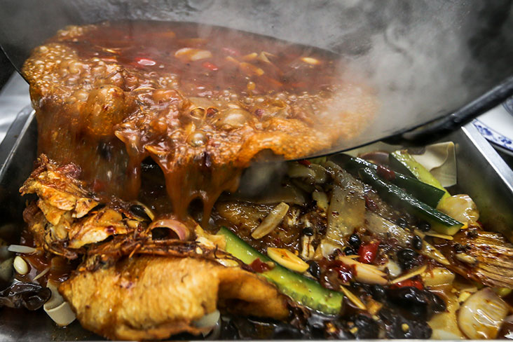 Once the sauce is ready, it is poured over the deep fried tilapia fish and served.