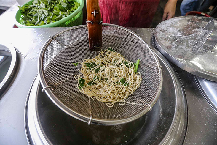 Once the noodles are ready, they will be ladled out and drained first.