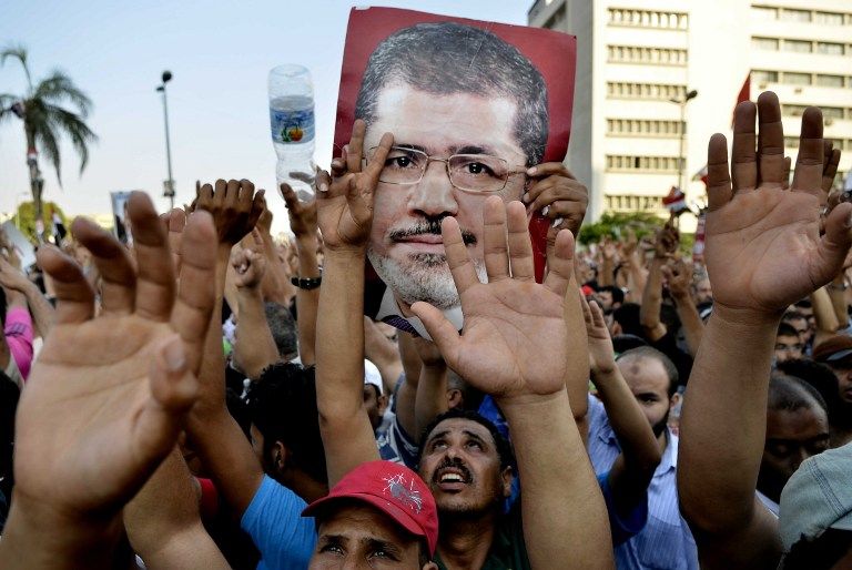 Egyptian supporters of the Muslim Brotherhood hold pictures of deposed president Mohamed Morsi as they shout slogans during a demonstration outside the Republican Guards headquarters in Cairo. u00e2u20acu201d Afp pic