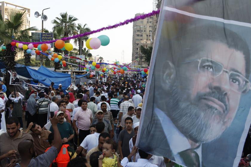 Members of the Muslim Brotherhood and supporters of deposed Egyptian President Mohamed Mursi hold a giant poster of Mursi as they walk with their families in the sit-in area of Rabu00e2u20acu2122a al- Adawiya Square, where they are camping, on the first day of the Ei