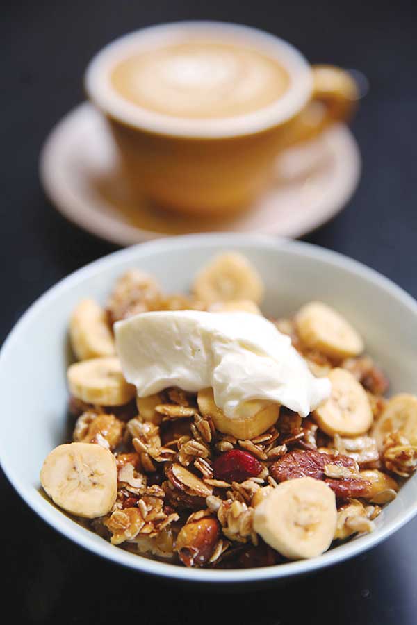 Perfect breakfast grub: a bowl of oats topped with homemade granola and a flat white