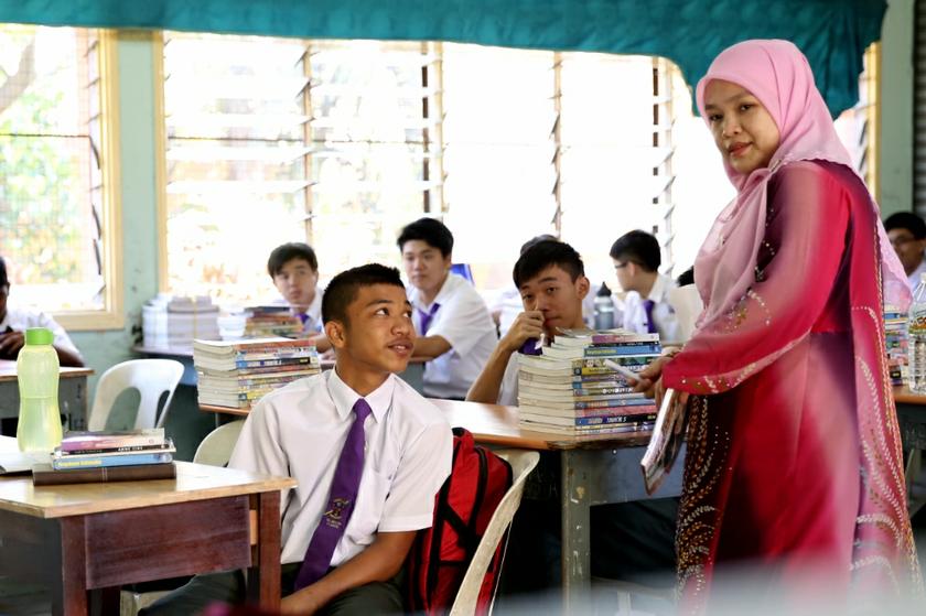 A teacher handing out textbooks to her students during their first day of school in Sekolah Menengah Kebangsaan (SMK) St Gabriel, Kampung Pandan, January 2, 2014. u00e2u20acu201d Picture by Saw Siow Feng