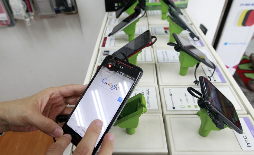 A customer tries out a HTC smartphone Butterfly S inside a mobile phone shop in Taipei July 30, 2013. u00e2u20acu201c Reuters pic