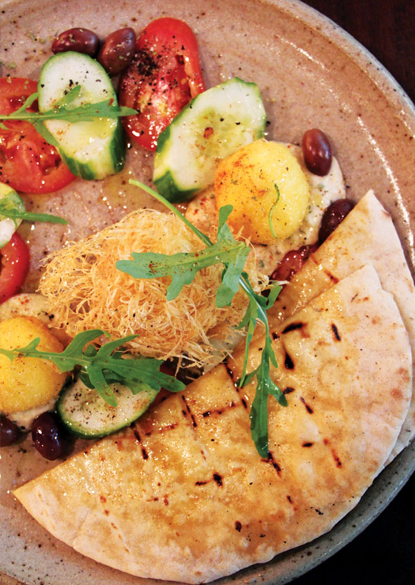 The hearty Turkish Common Man Breakfast – a soft-boiled organic egg wrapped in deep-fried phyllo, served with cucumber, tomatoes, olives, hummus and pita bread