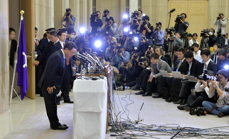 Tokyo Governor Naoki Inose (left) bows as he finishes an emergency press conference to announce his resignation at the Tokyo Metropolitan Government offices on December 19, 2013. u00e2u20acu201d AFP pic