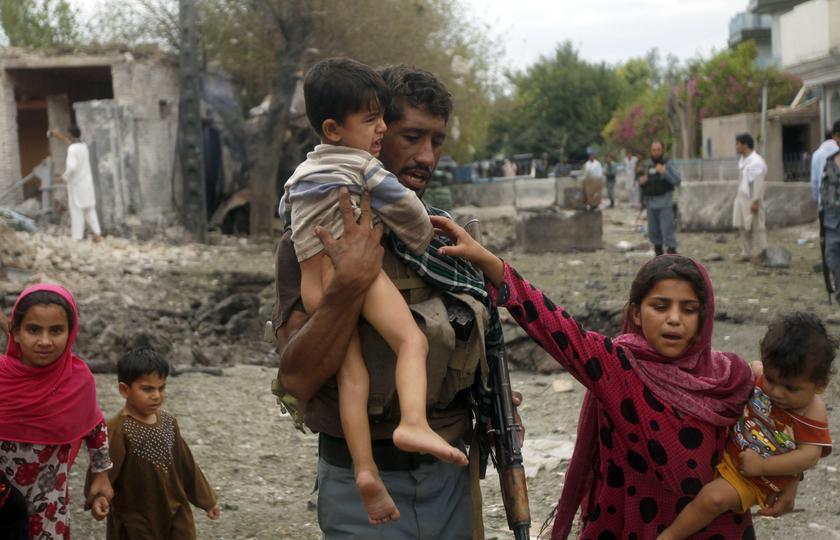 An Afghan policeman carries a boy as he helps local residents move away from the site of a suicide attack at the Indian consulate in Jalalabad province August 3, 2013. u00e2u20acu201c Reuters pic