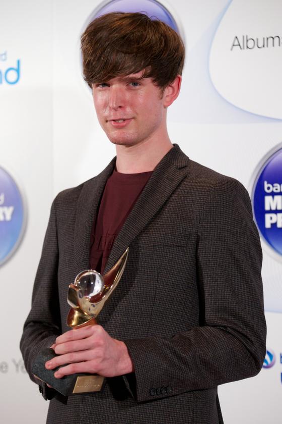 British singer-songwriter and producer James Blake poses with the 2013 Mercury Prize winners trophy for his second album 'Overgrown' during the awards ceremony in central London on October 30, 2014. u00e2u20acu201d AFP