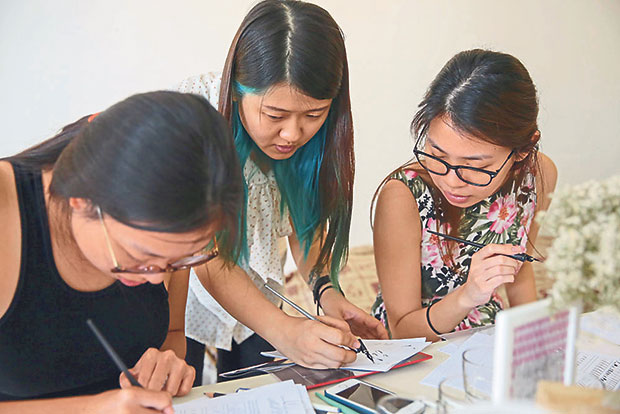 Inez Tan (centre) teaches how to write the proper way