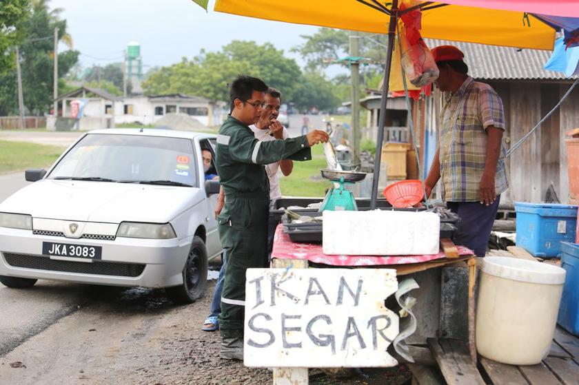 A customer stops by to buy some fresh fish.