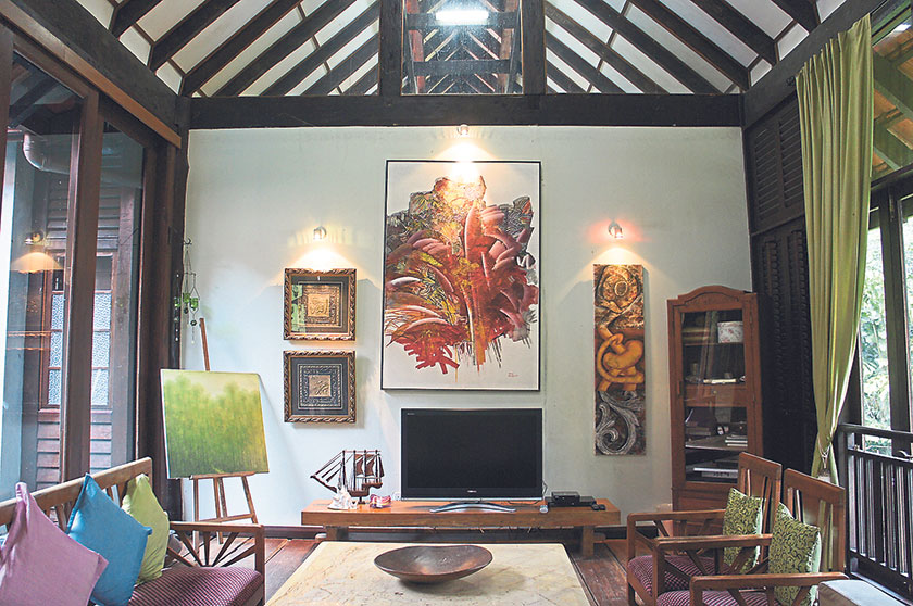 Vibrant artworks and soft furnishings brighten up the living room at Kuang Kampung Retreat