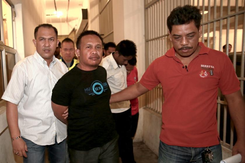 La Ode Ardi Rasila, the main suspect in the shooting of an Ambank officer, is being escorted by policemen in Kuala Lumpur, November 19, 2013. u00e2u20acu201d Picture by Saw Siow Feng