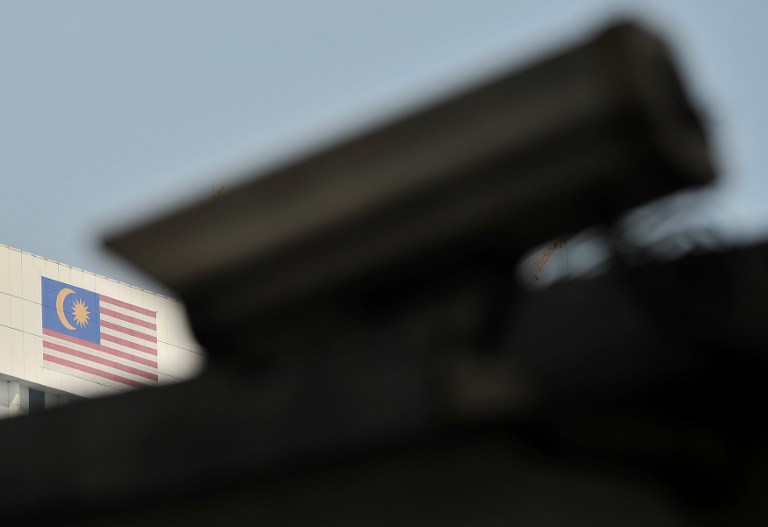 A closed circuit television camera (foreground) is seen near a Malaysian flag in Kuala Lumpur on November 1, 2013. u00e2u20acu201du00c2u00a0AFP pic
