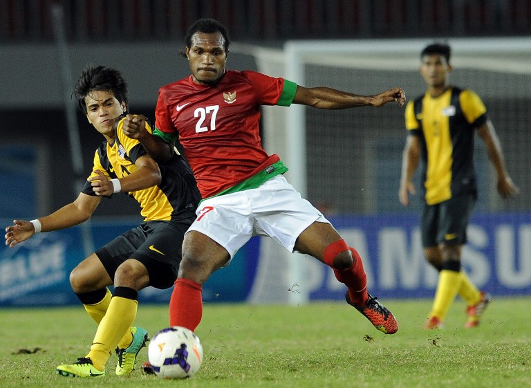 Nelson Alom (centre) of Indonesia fights for ball with Mansor Muhd Nazmi Faiz of Malaysia (left) during the men's semi-final SEA Games football match between Malaysia and Indonesia in Naypyidaw on December 19, 2013. u00e2u20acu201d AFP pic