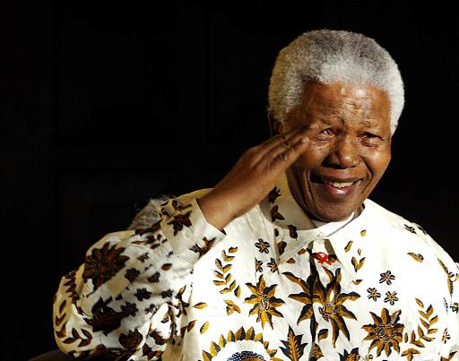 Nelson Mandela, 1918-2013. File photo of July 18, 2003 shows the former South Africa President saluting the South African military health service band that came to play a specially composed march for his 85th birthday in Johannesburg. — AFP pic