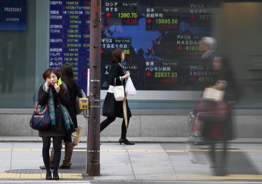 Pedestrians stand in front of a stock quotation board displaying stock prices outside a brokerage in Tokyo January 15, 2014. u00e2u20acu201d Reuters pic