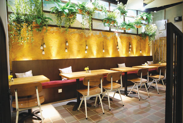 The back of the restaurant resembles an outside terrace with white light and plants