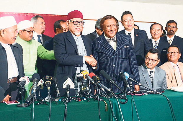 Hadi (left) and Kadir shake hands during a press conference to announce the alliance between the two parties in Kuala Lumpur on Wednesday. — Picture by Saw Siow Feng