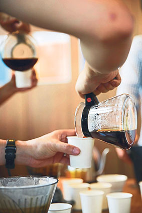 Pouring cups of coffee to share and sample