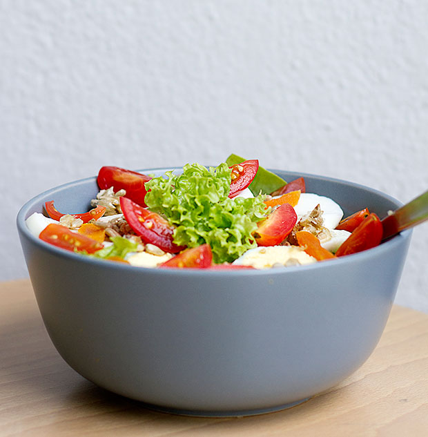 A summer salad of red and green coral, butterhead lettuce, rocket, honey roasted sunflower seeds, dried apricots and hard-boiled egg, with a balsamic dressing