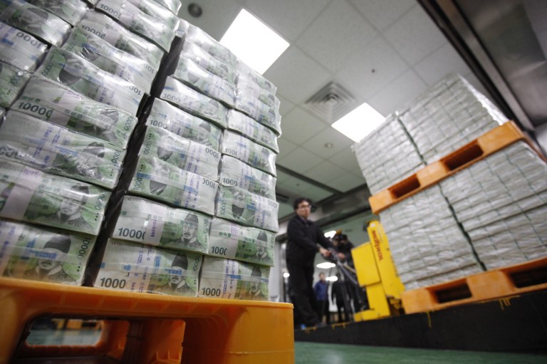 An employee moves stacks of South Korean won for delivery to commercial banks at the Bank of Korea's headquarters in Seoul on February 5, 2013.u00e2u20acu201d AFP pic