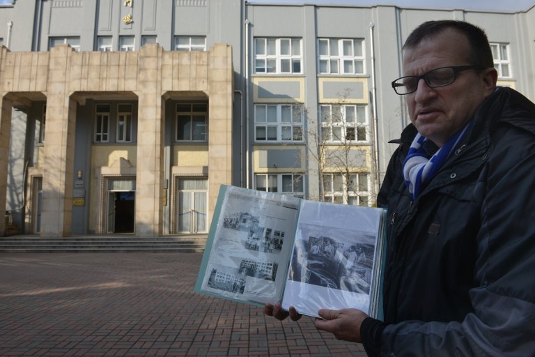 This photo taken on January 14, 2014 shows Sven Serrano, a history teacher at Shanghai High School, standing outside the main building of the school displaying photos of when it was used by the Japanese as a prison camp known as Lunghwa camp during World 