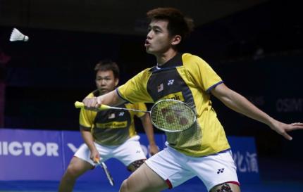 Malaysia's Tan Wee Kiong (R) hits a return next to his partner Hoon Thien How during their men's doubles final match against South Korea's Lee Yong-dae and Yoo Yeon-seong at the China Open Badminton Tournament in Shanghai, November 17, 2013. 