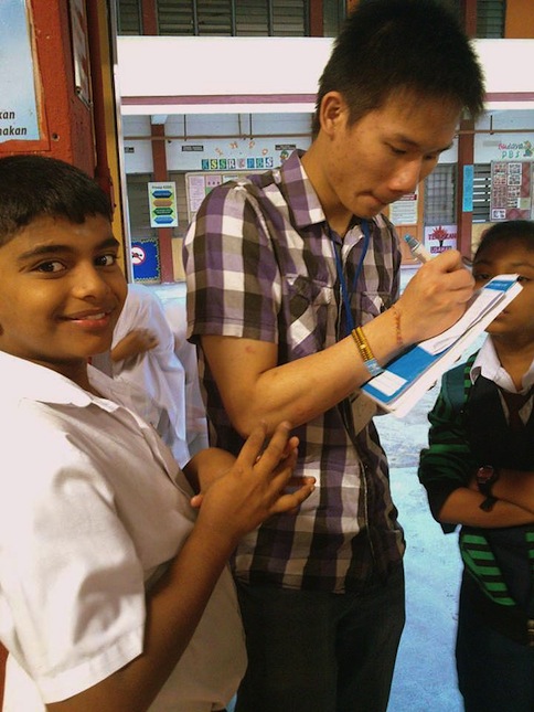 Wei Jie, one of our volunteers signing autographs for the kids.