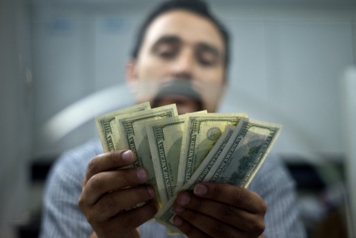 An Indian moneychanger counts US dollar bills at his office in New Delhi on June 20, 2013. u00e2u20acu201d AFP pic 