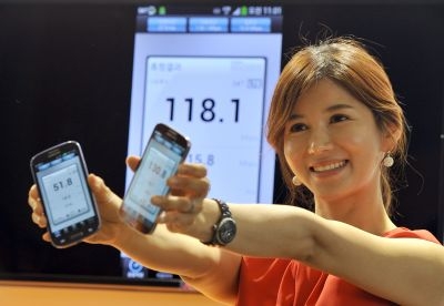 A South Korean model shows Galaxy S4 smartphones displaying wireless data speed via SK Telecom’s new mobile network, LTE-Advanced, in Seoul on June 26, 2013. — AFP pic