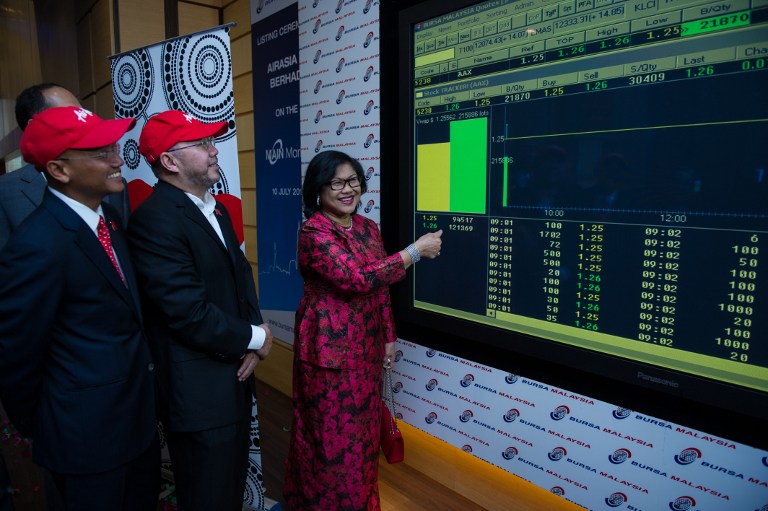 Chairman of AirAsia X Berhad Tan Sri Rafidah Aziz (right) points to a digital display showing share prices after the listing debut of AirAsia X at Malaysia Stock Exchange in Kuala Lumpur on July 10, 2013. u00e2u20acu201c AFP pic