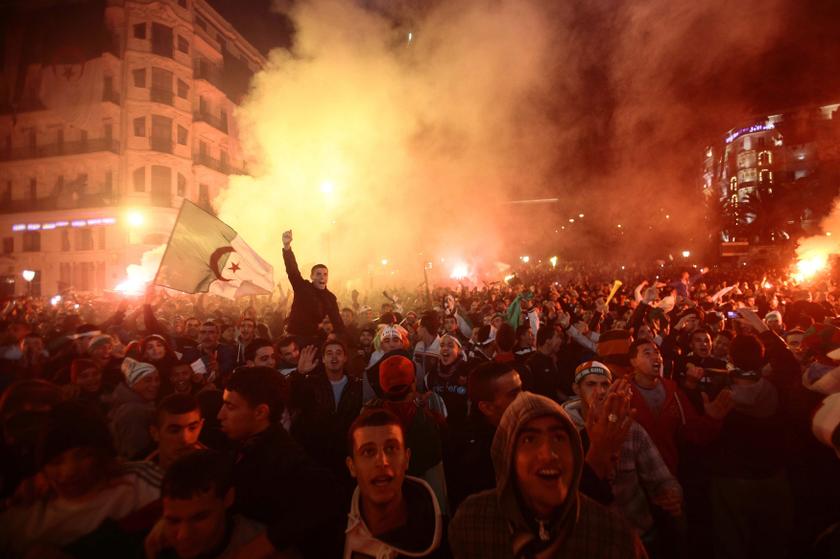 Fans of Algeria's football team hold the country's national flag as they celebrate in downtown Algiers, after their team defeated Burkina Faso in their 2014 World Cup qualifying second leg playoff match, November 19, 2013. u00e2u20acu201d Reuters pic