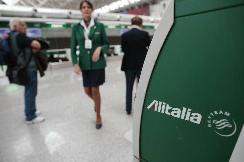 An Alitalia worker walks near an Alitalia auto check-in machine at Fiumicino airport in Rome October 11, 2013. u00e2u20acu201d Reuters pic