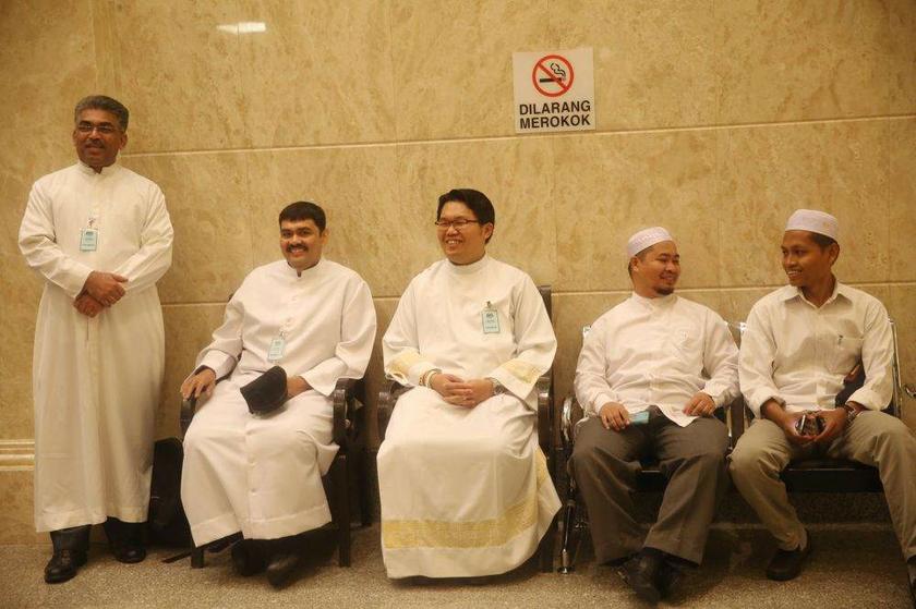 Three Catholic priests (left) and two Muslim men (right) waiting outside the Court of Appeal in Putrajaya on August 22, 2013 for the hearing of the Catholic Churchu00e2u20acu2122s appeal on the u00e2u20acu02dcAllahu00e2u20acu2122 case. u00e2u20acu201d Picture by Choo Choy May 