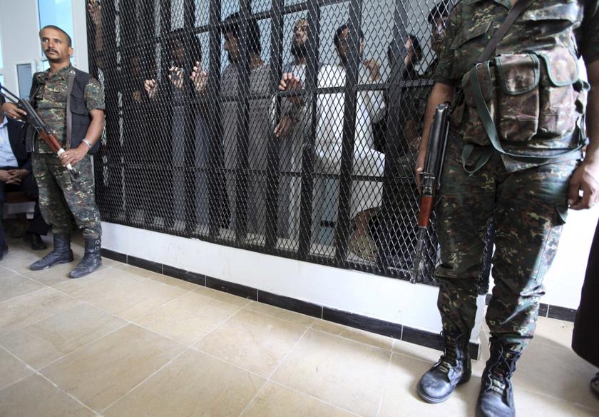 Armed soldiers stand guard outside defendants' holding cell during a trial session where five Saudi citizens accused of being involved with al-Qaeda, in Sanaa, Sept 12, 2013. u00e2u20acu201d Reuters pic